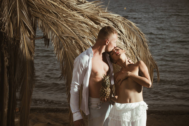 Giovane coppia nuda in piedi su una spiaggia di sabbia tropicale
 - Foto, immagini