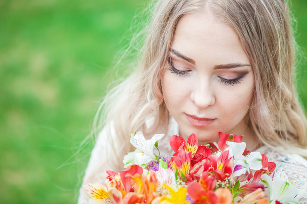 portrait of a blonde girl with a bouquet of flowers. close-up - Fotó, kép