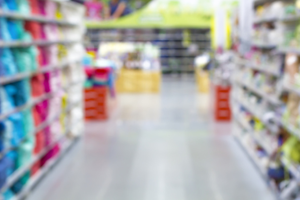 Absztrakt elmosódott szupermarket folyosó színes polcokkal és felismerhetetlen vásárlókkal háttérként - Fotó, kép