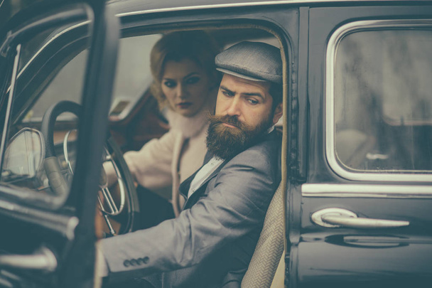 Travel and business trip or hitch hiking. Retro collection car and auto repair by mechanic driver. Couple in love on romantic date. Bearded man and sexy woman in fur coat. Escort of girl by security - Zdjęcie, obraz