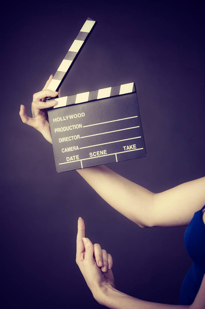 Woman holding professional film slate, movie clapper board. Hollywood production objects concept. Studio shot on black background. - Fotoğraf, Görsel