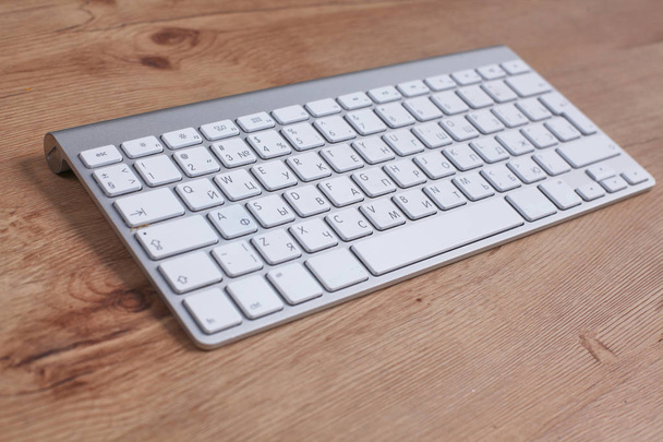 Modern aluminum keyboard on the wooden table in the office - Photo, Image
