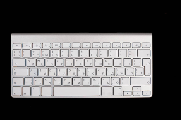 Modern aluminum keyboard top view isolated on a black background - Photo, Image