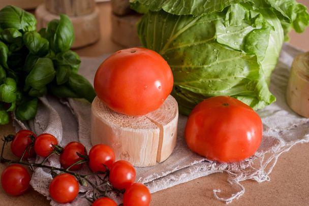 Tomatoes are large and cherry on a branch. Cabbage cabbage. On a wooden board, stand. Fresh basil. On a linen mint linen old napkin. Preparation of salad. Healthy Eating - Foto, Imagem