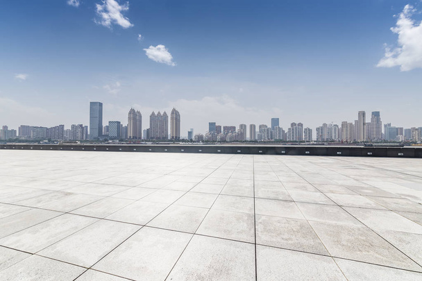 skyline panoramico ed edifici con pavimento quadrato in cemento vuoto
 - Foto, immagini