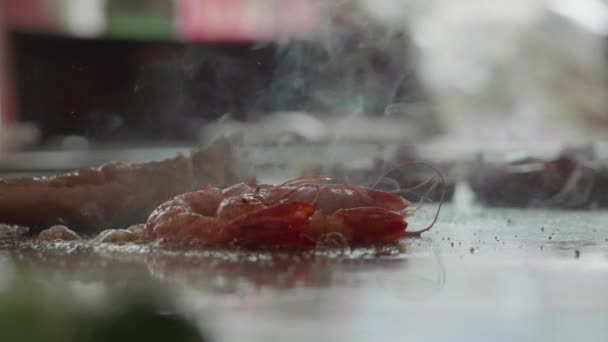 Slow motion shot of skilled teppanyaki chef cooking shrimp - Footage, Video