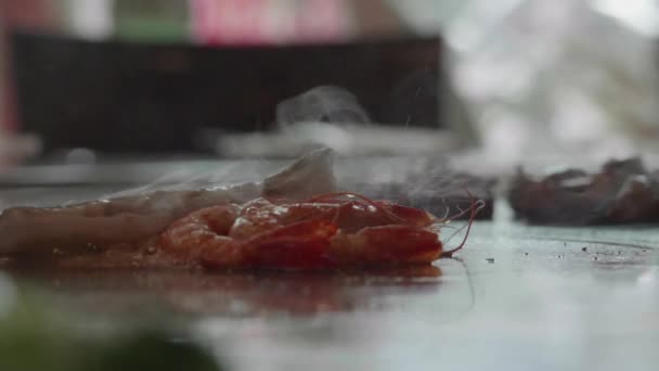 Slow-motion shot van geschoolde teppanyaki chef-kok koken van garnalen - Video