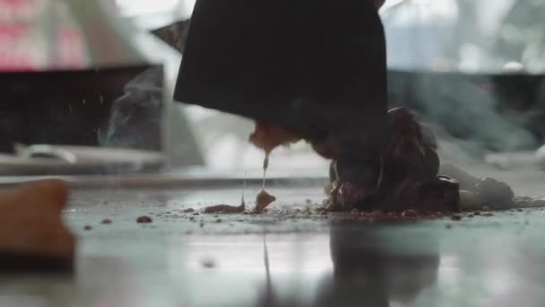 Slow-motion shot van geschoolde teppanyaki chef-kok koken rundvlees - Video