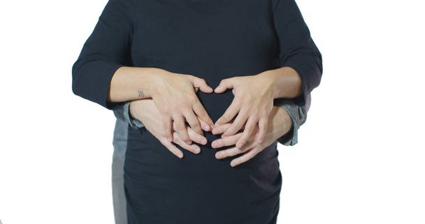 Символ смешанной расы пара сердца Валентина руки заперты вокруг беременного живота
 - Фото, изображение