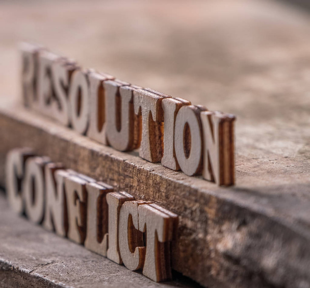 Текст "RESOLUTION" и "CONFLICT" на деревянном фоне
. - Фото, изображение