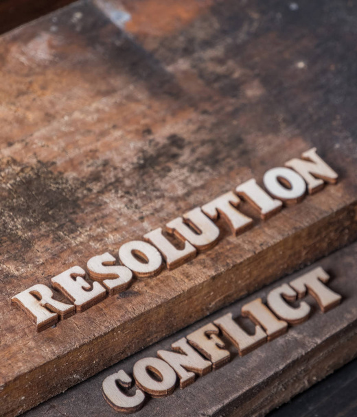 'Resolutie' en 'Conflict' tekst op houten achtergrond. - Foto, afbeelding