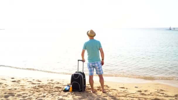 Mann mit Koffer am Strand. Sommerreise- und Urlaubskonzept - Filmmaterial, Video