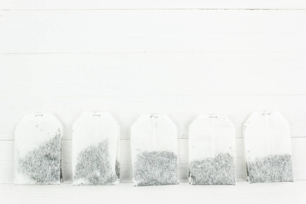 Χάρτινες τσάντες τσαγιού λευκό ξύλινο τραπέζι. Χώρο αντίγραφο για το κείμενο - Φωτογραφία, εικόνα