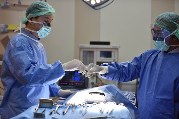 Операційна.scrub медсестра готує медичні інструменти для операції. Медична команда Виконуючи хірургічну операцію в сучасній операційній.Обладнання та медичні пристрої в гібридній операційній кімнаті синій фільтр, хірургічні процедури, операційна кімната
  - Фото, зображення