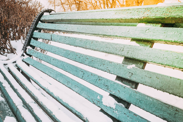 Groene houten bankje in winter Park - Foto, afbeelding
