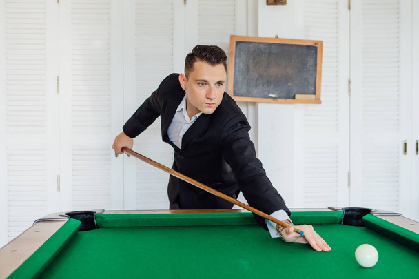 Young handsome man dressed in classic costume playing billiard game alone - Fotoğraf, Görsel