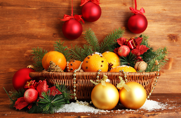 christmas composition in basket with oranges and fir tree, on wooden background - Фото, зображення
