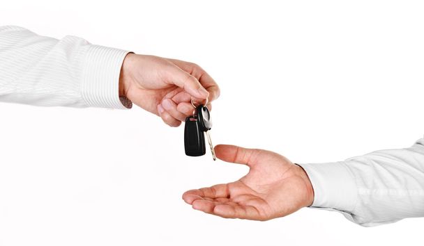 Male hand holding a car key and handing it over to another perso - Fotoğraf, Görsel