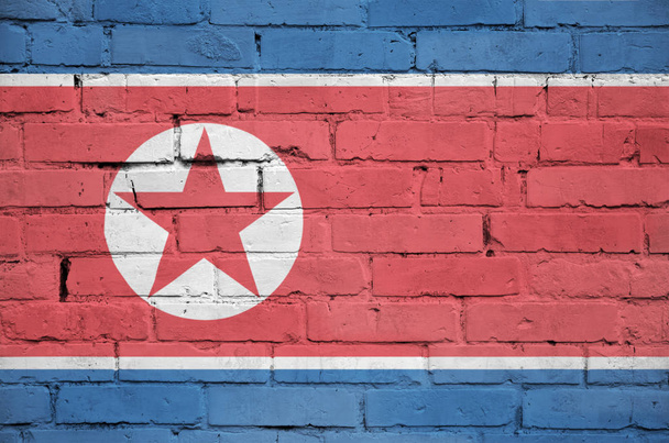 Észak-Korea zászlója egy régi téglafalra van festve. - Fotó, kép