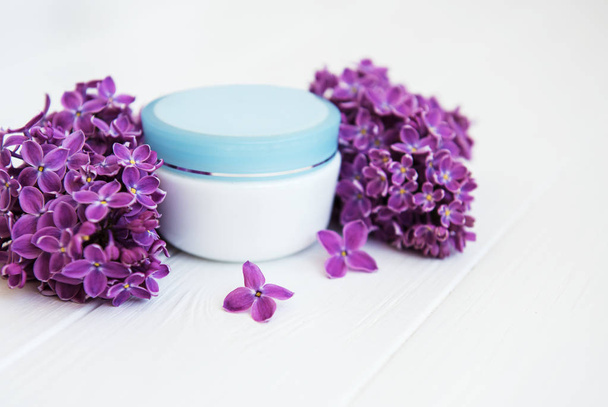 fialovými květy a kosmetický krém na bílém pozadí dřevěná - Fotografie, Obrázek