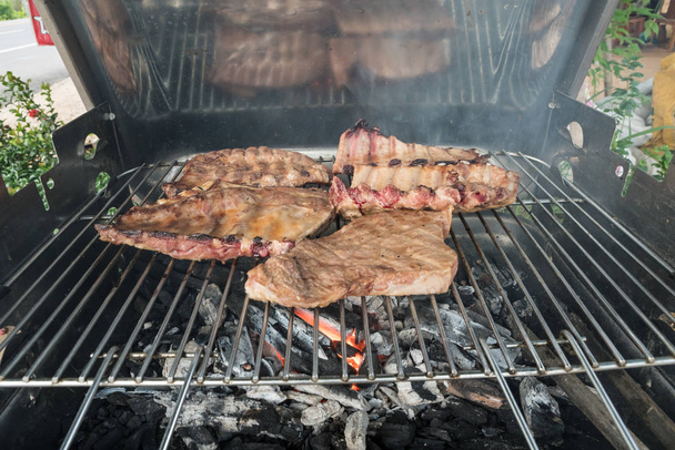 Sul barbecue a carbone ci sono costolette e una gustosa bistecca.
 - Foto, immagini