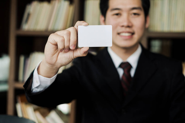 jovem empresário sorrir e segurando cartão de visita em branco no escritório, conceito de negócio - Foto, Imagem