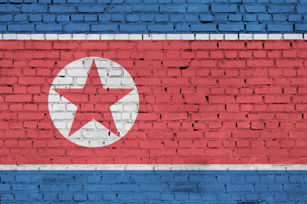 Észak-Korea zászlója egy régi téglafalra van festve. - Fotó, kép