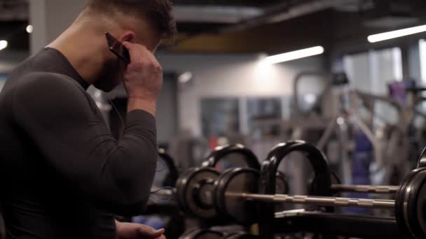 Ο άνθρωπος που χρησιμοποιούν κινητό τηλέφωνο στο γυμναστήριο - Πλάνα, βίντεο