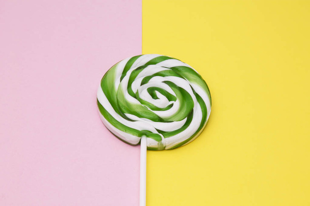 colorful lollipops on yellow and pink background - Foto, afbeelding