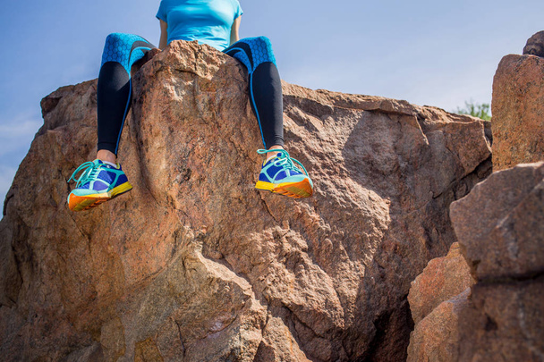 Vonzó női futó bevétel alkalom után ülve egy szikla a csupasz láb, Nézd Odalentről kültéri jogging - Fotó, kép