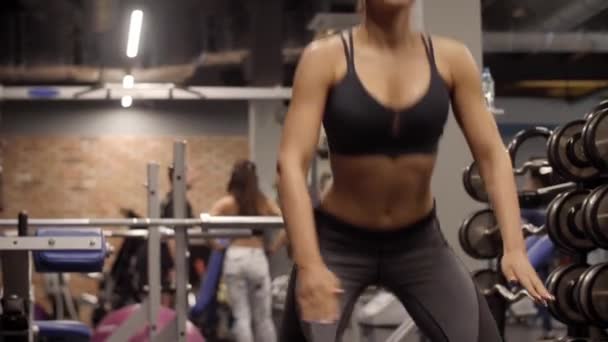 Mujer en cuclillas y saltando en el gimnasio
 - Metraje, vídeo