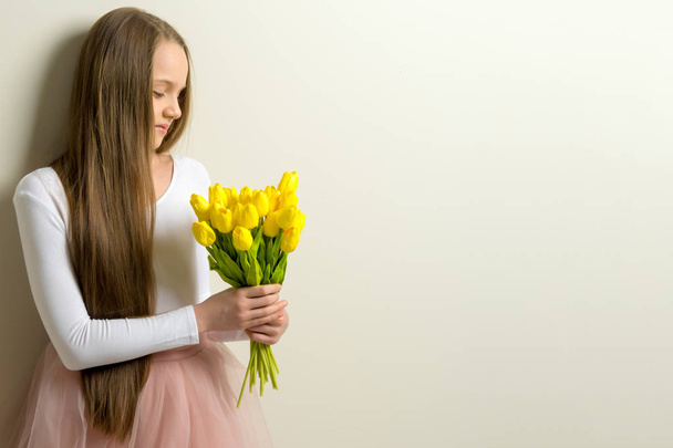 Little girl with a bouquet of tulips. - Foto, imagen