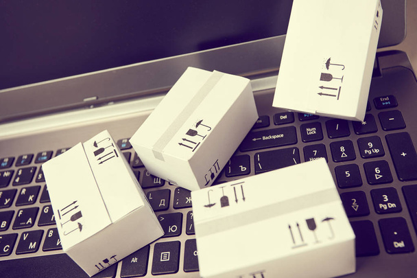 delivery packaging boxes on laptop keyboard - Fotó, kép