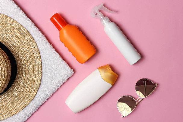 sunscreen, towel, hat, glasses on a colored background. Cosmetics for prevention of sunburn.top view, flatlay  - Фото, зображення