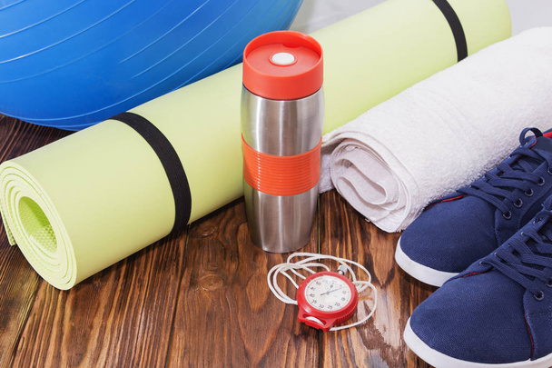 Equipamiento deportivo, bola adecuada, esterilla de yoga, botella de agua y cronómetro de cerca
 - Foto, Imagen