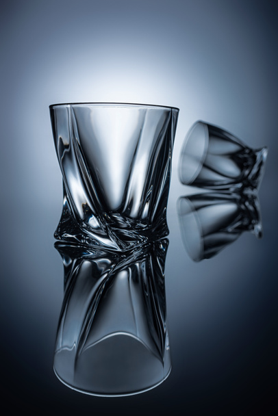 transparent elegant whiskey glasses on grey with reflections - 写真・画像