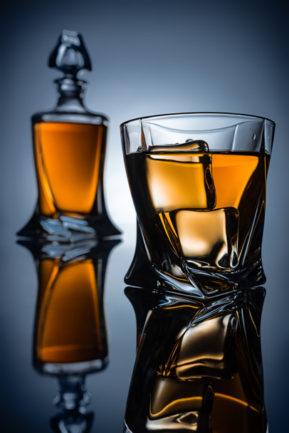 mise au point sélective de la bouteille et du verre avec whisky et glaçons, sur gris
 - Photo, image