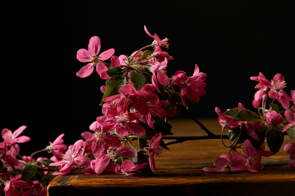 közeli lövés aromás rózsaszín cseresznyevirág fából készült asztali fekvő - Fotó, kép
