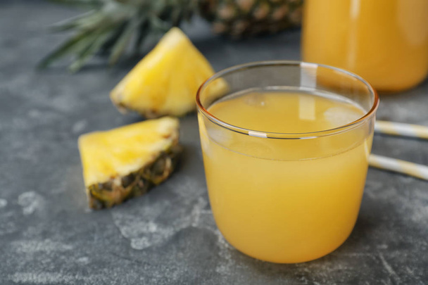 Glass with delicious pineapple juice on table - Foto, immagini