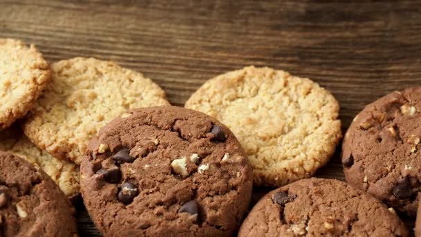 Různé chutné cookies sušenky na dřevěné pozadí - Záběry, video