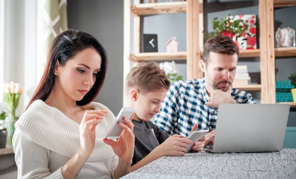 Family using digital devices: laptop, tablet and smartphone at home - Photo, image