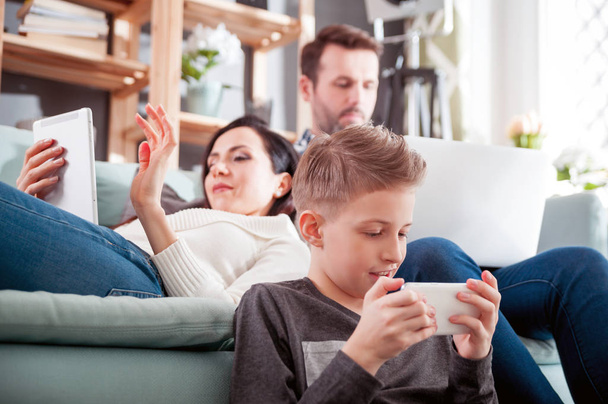 Family using digital devices: laptop, tablet and smartphone at home - Фото, зображення
