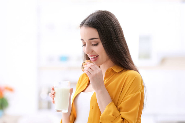 Beautiful pregnant woman drinking milk and eating cookies at home - Φωτογραφία, εικόνα
