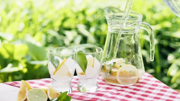 Lemonade with ice, orange and lime slices in a glass - Footage, Video