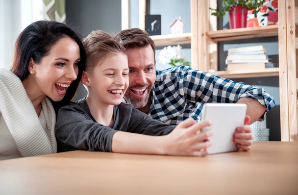 Young family using digital tablet at home - Valokuva, kuva