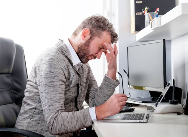 Przepracowany zmęczony biznesmen, siedząc w pracy w biurze  - Zdjęcie, obraz