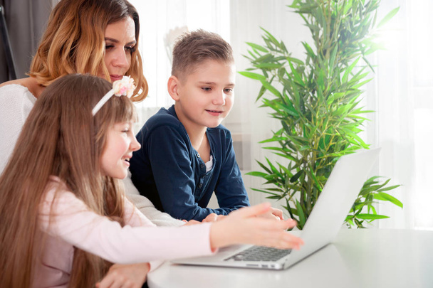 Young mother with children using laptop at home - Valokuva, kuva