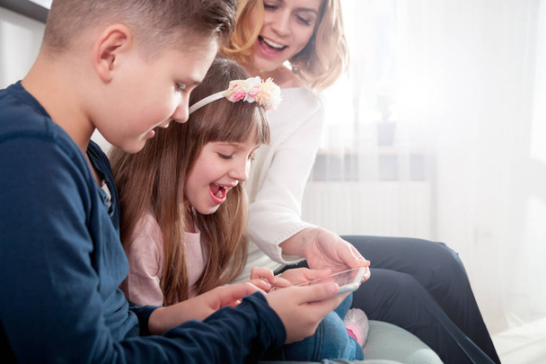 Young mother with children using digital tablet at home - Foto, Bild