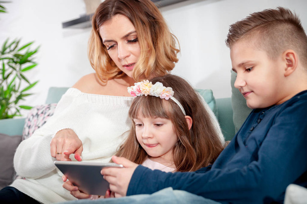 Young mother with children using digital tablet at home - Valokuva, kuva