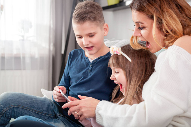 Young mother with children using digital tablet at home - Foto, Imagen